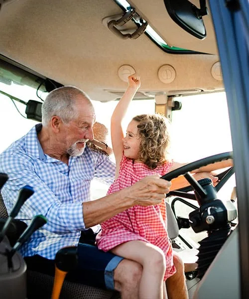 Familie mit Traktor auf dem Feld eines landwirtschaftlichen Betriebs